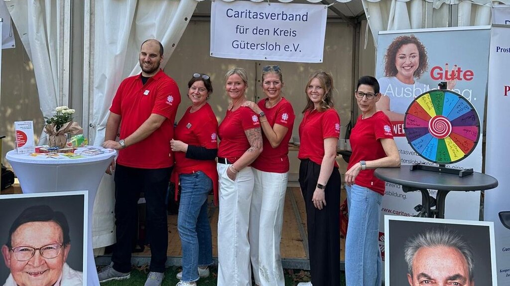 Das Team der Caritas Gütersloh posiert vor einem Ausstellungszelt.