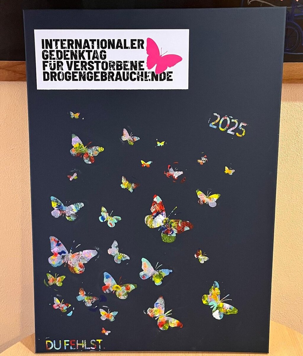 Eine schwarze Stellwand mit gebastelteten bunten Schmetterlingen anlässlich des Int. Tages für verstorbene Drogengebrauchende